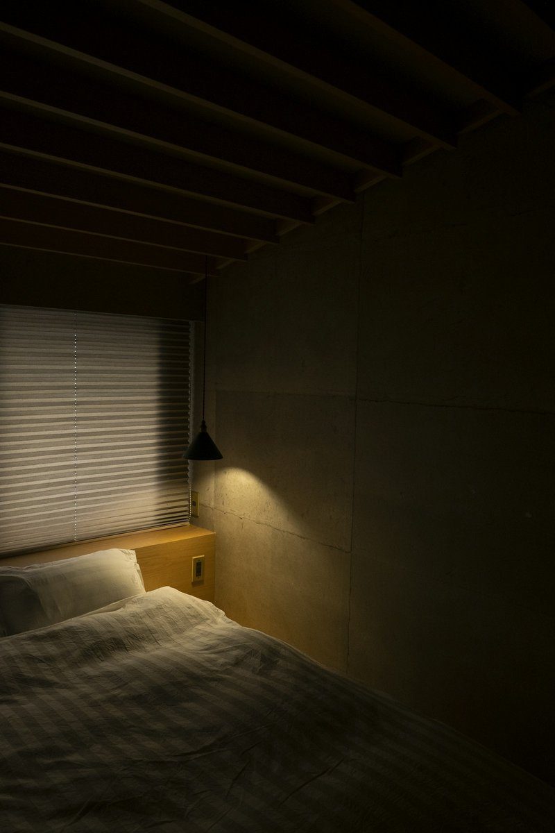 Chambre dans la pénombre éclairée par une petite lampe murale